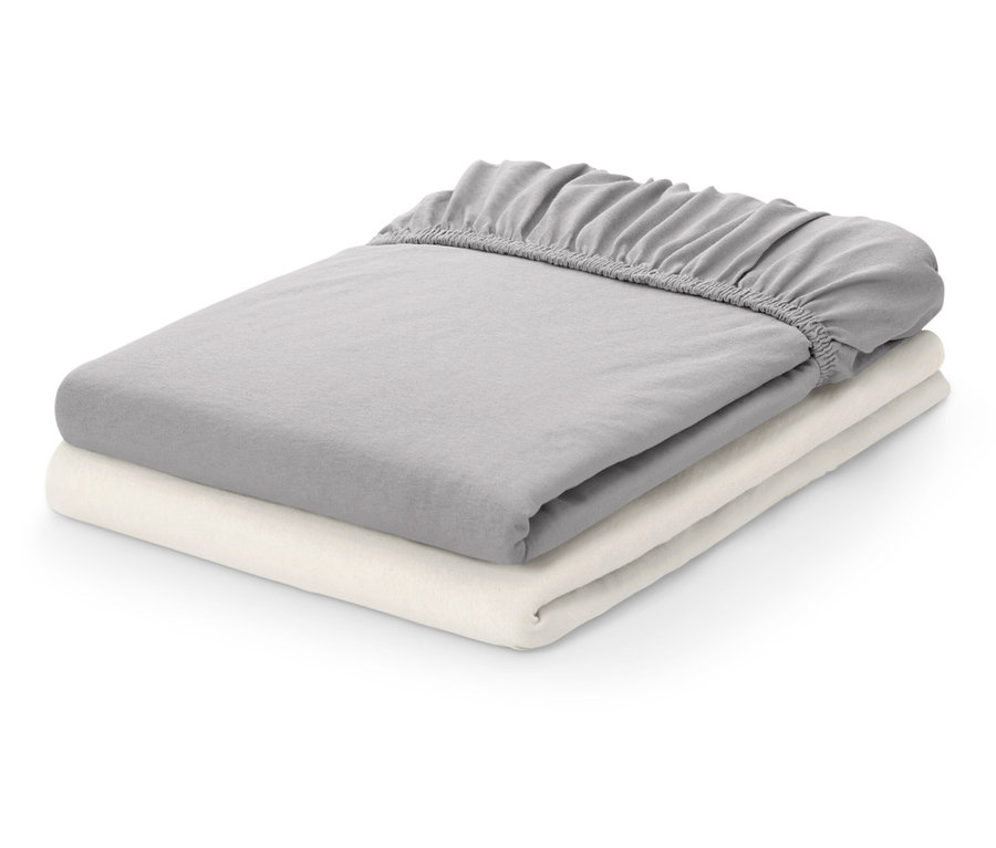 Dvě složené prostěradla: šedé a krémové.