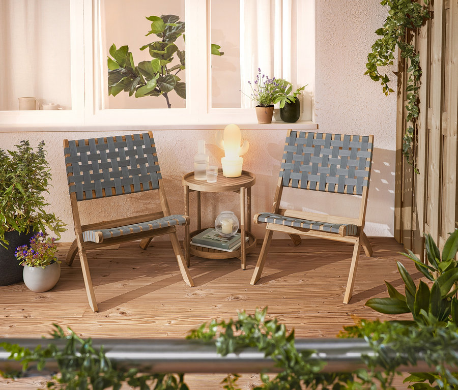 Na terase stojí dvě pletené židle a odkládací stolek.