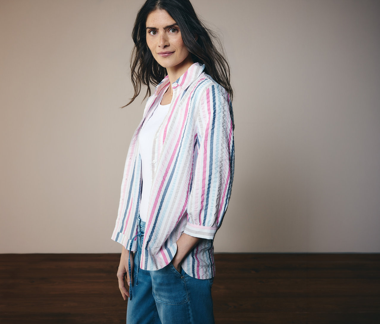 Žena v proužkované košilové halence CECIL s tříčtvrtečními rukávy a džínách. Jednu ruku má v kapse.