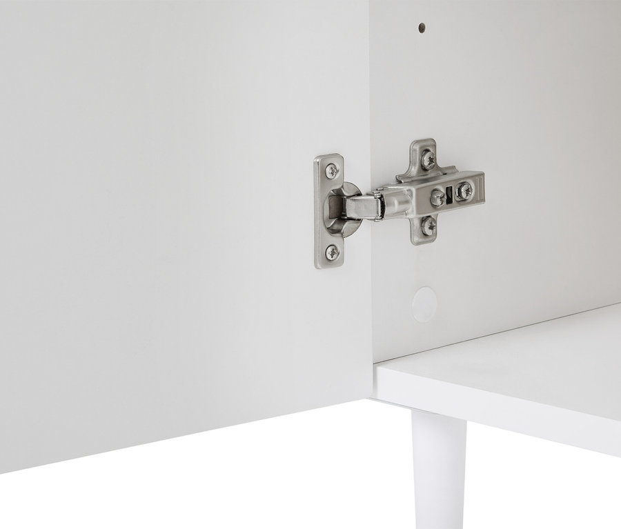 Detailní pohled na bílou skříňku se stříbrným pantem připevněným ke dveřím.