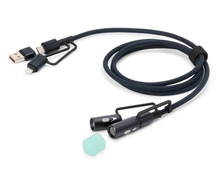 Modrý nabíjecí kabel s konektory USB, USB-C a Lightning, dvěma malými LED světly a silikonovým nástavcem leží na bílém pozadí.