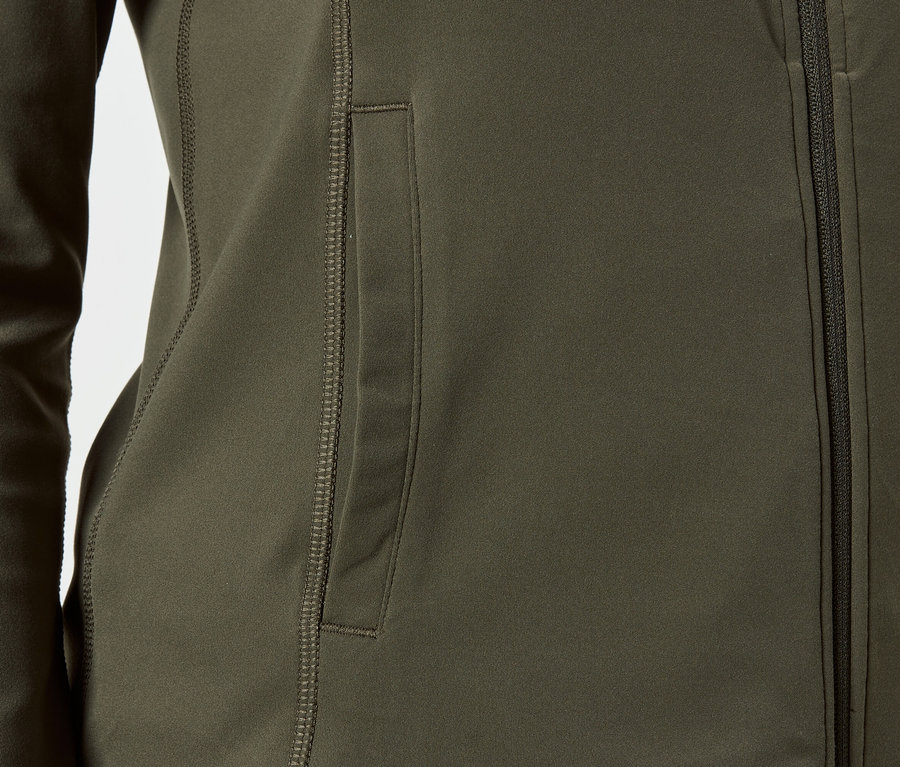 Detail olivové bundy se zipem a boční kapsou.