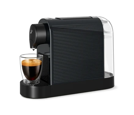 Káva teče do sklenice z černého kávovaru Cafissimo pure+.