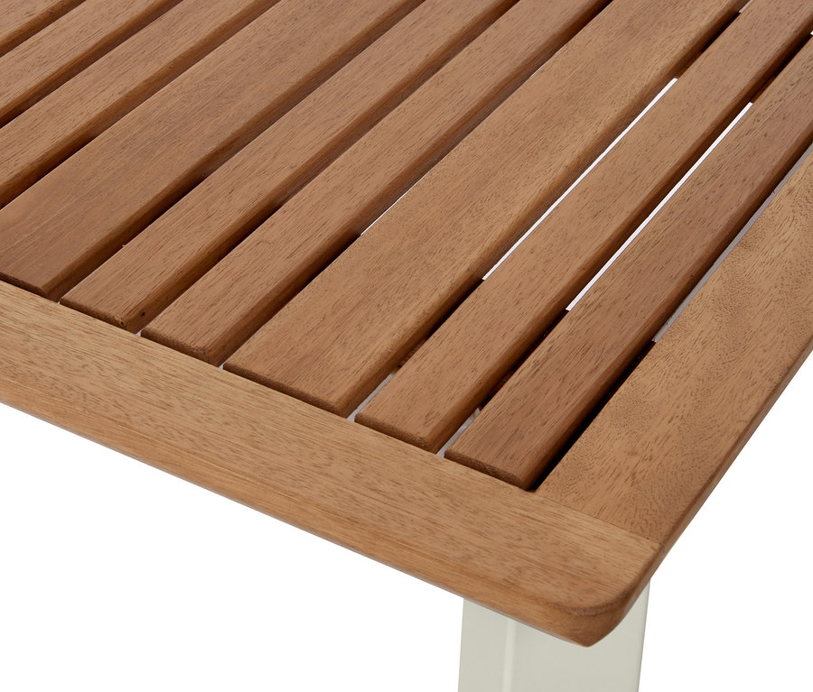 Detail rozkládacího stolu »Liska« z eukalyptového dřeva s lamelovou deskou a bílou nohou.