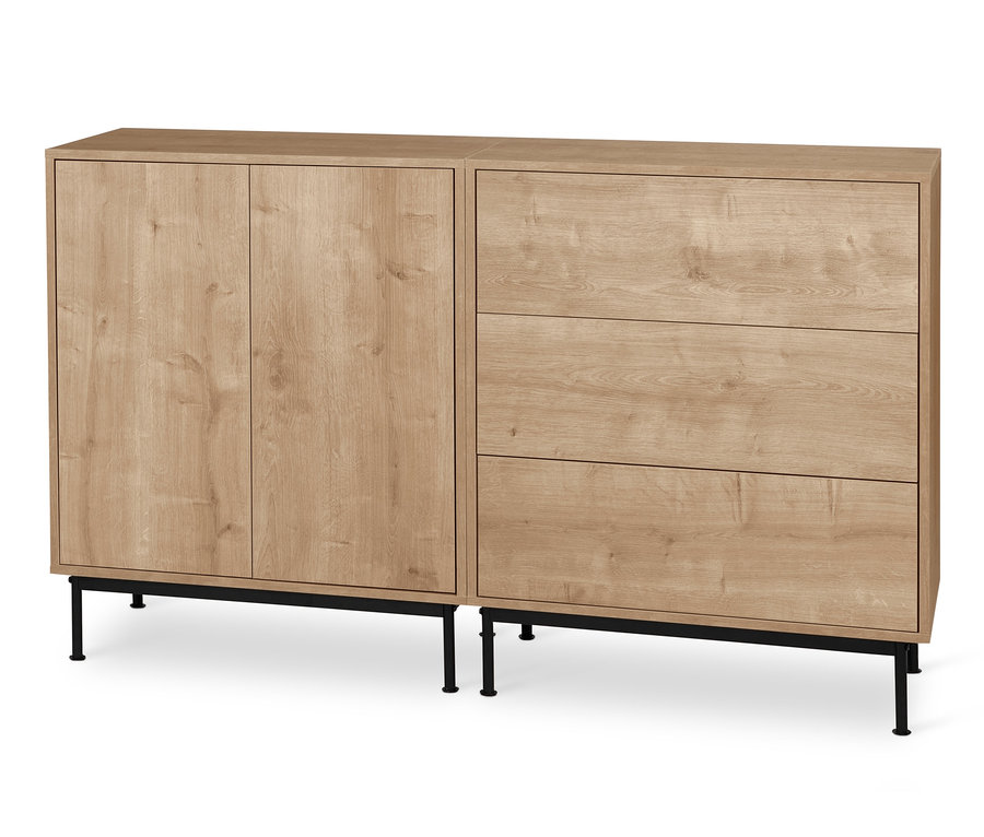 Dva moduly regálu Flemming v dubovém dekoru stojí vedle sebe na černých kovových podnožkách Flemming. Jeden modul má dvoje dvířka, druhý tři zásuvky.