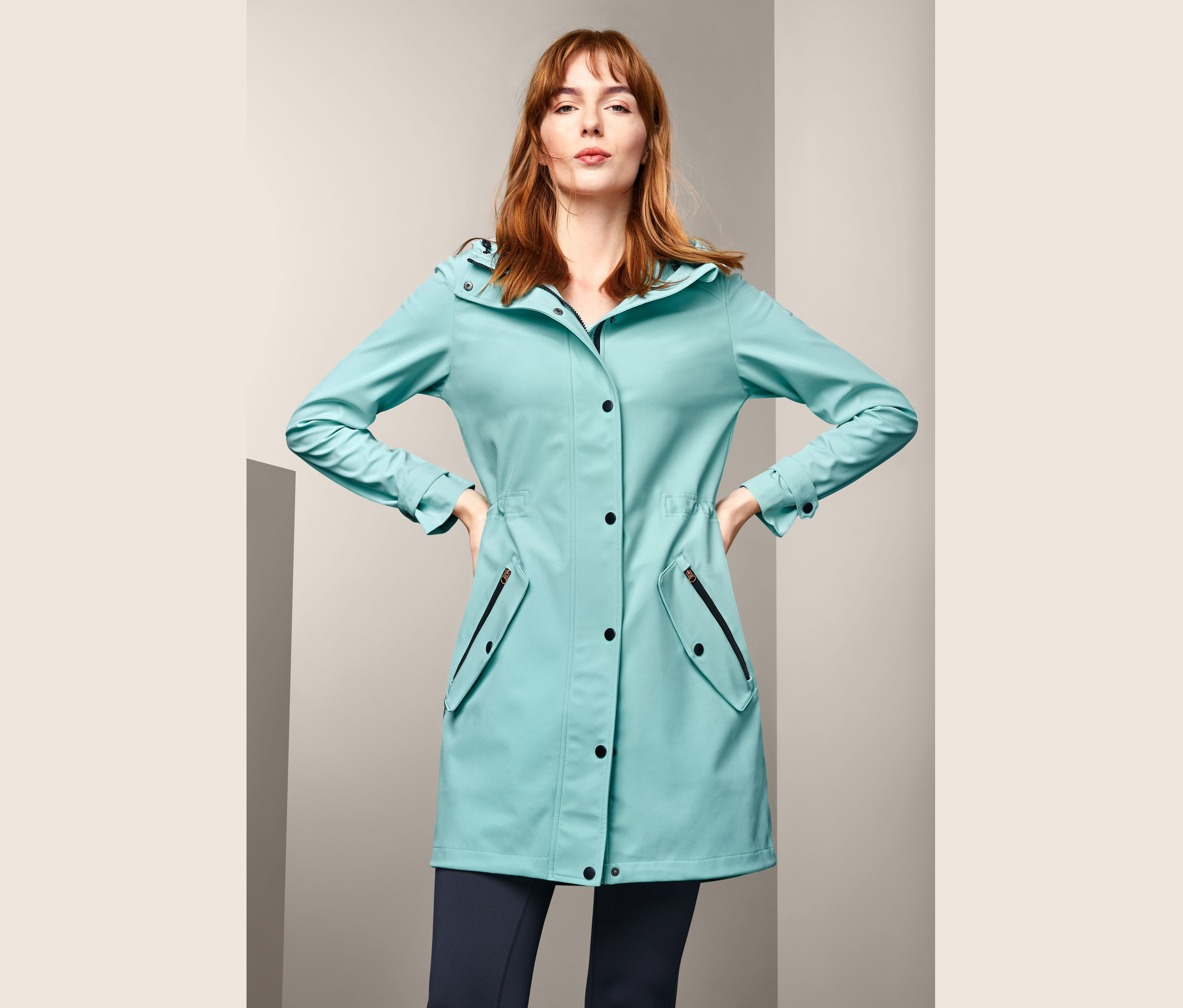 Žena pózuje v softshellovém kabátě.