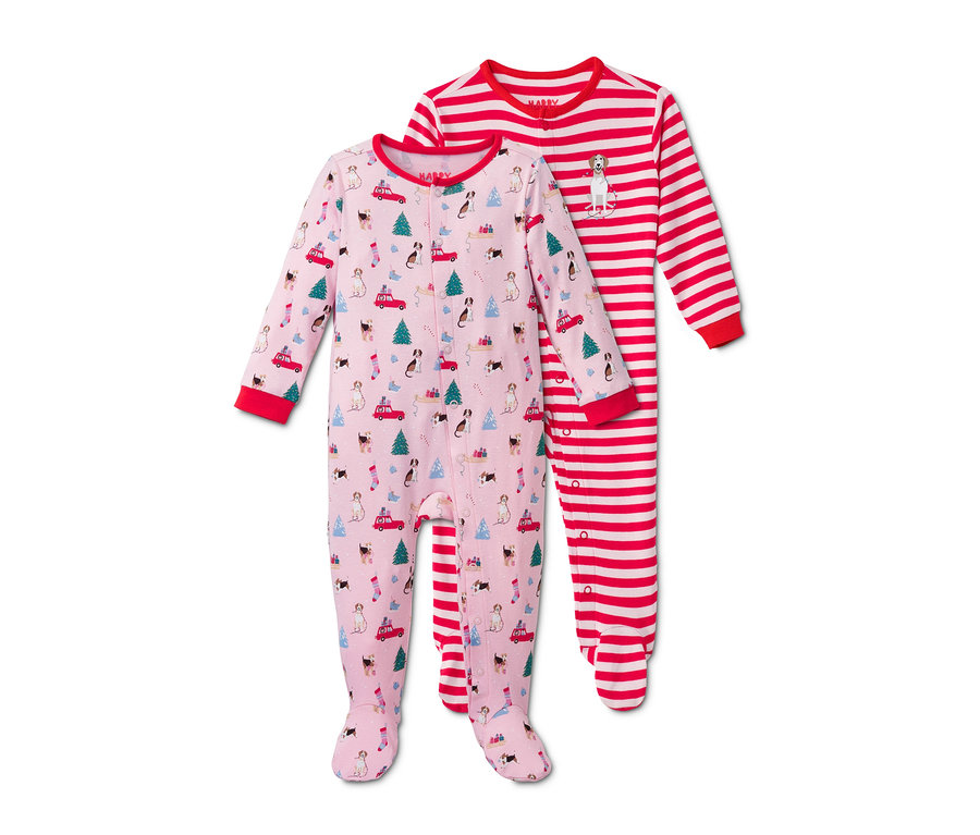Dvoje dětská pyžamka s vánočním motivem. Jedno růžové se vzorem psů, vánočních stromků a aut, druhé červeno-bílé proužkované s obrázkem psa.