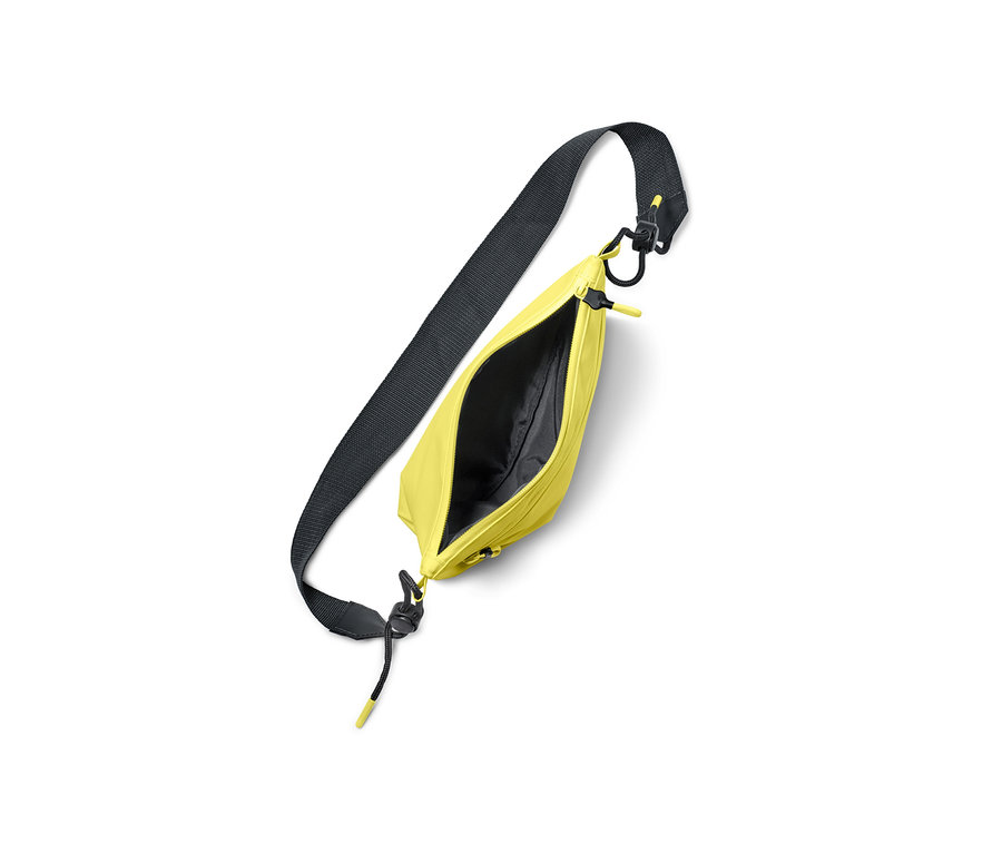 Žlutá taška přes rameno s černým popruhem a zipem.
