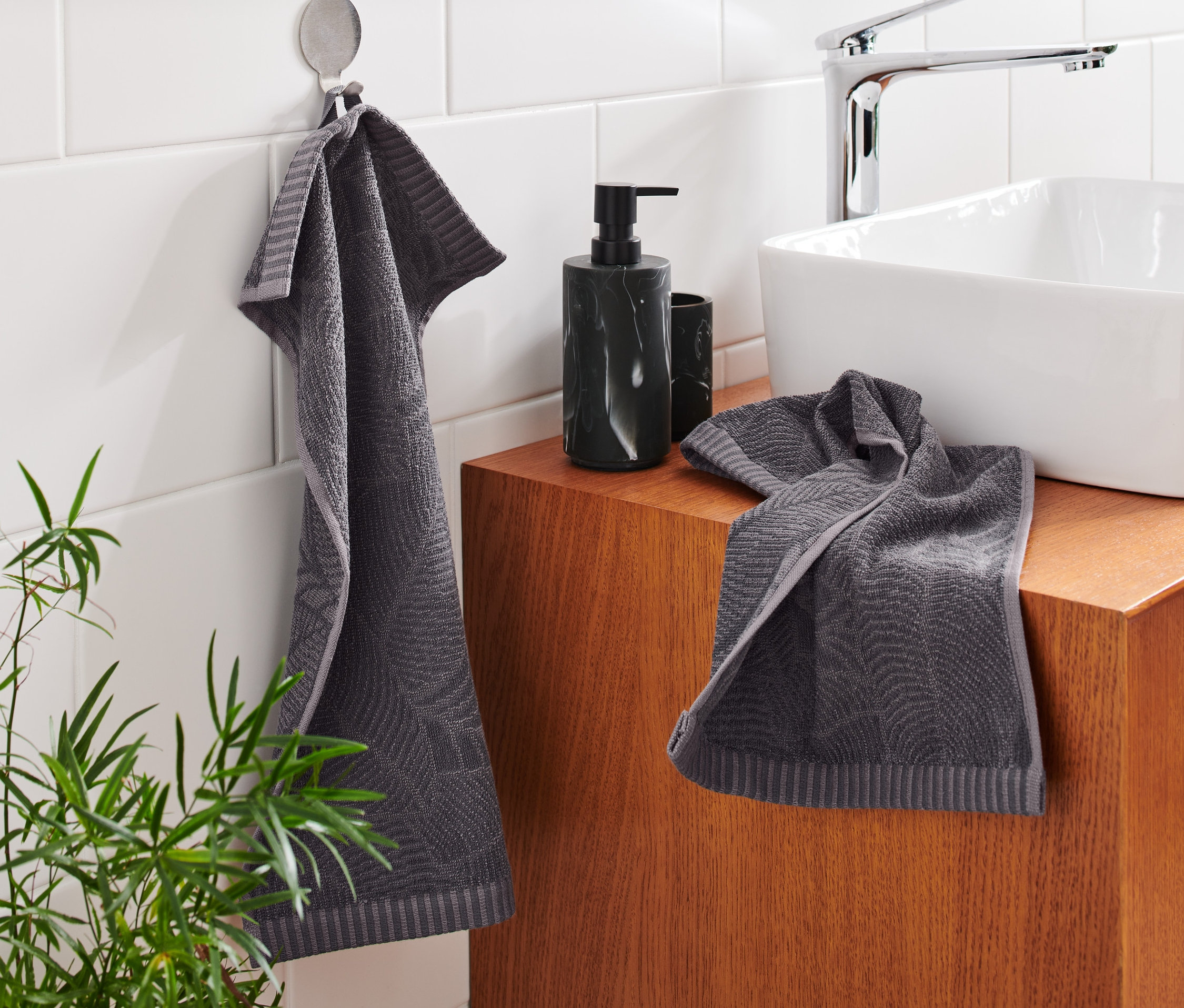 V koupelně visí a leží dva žakárové ručníky pro hosty.