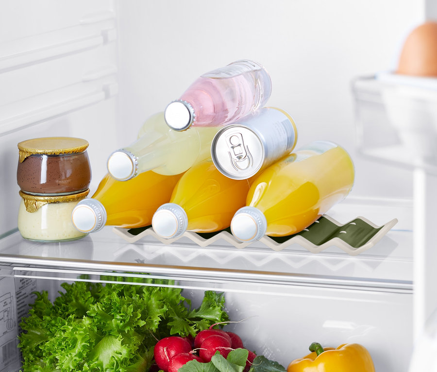V lednici jsou džemy, nápoje v držáku na láhve do lednice, zelenina a vejce.