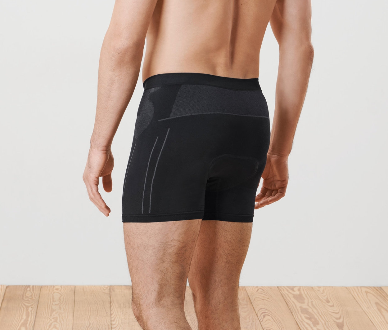 Muž pózuje zády ke kameře a má na sobě cyklistické spodky.