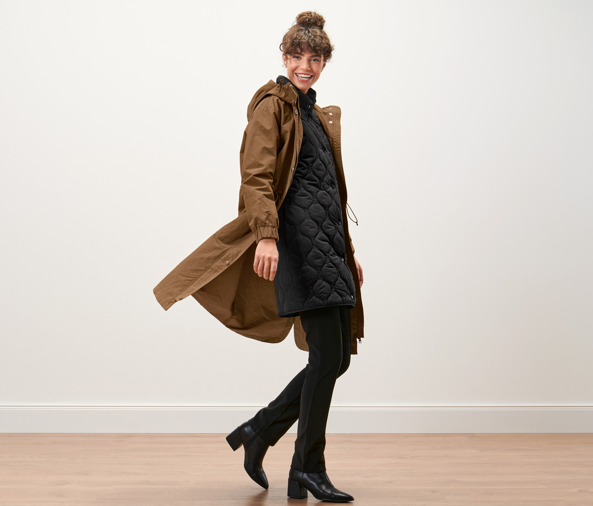 Žena kráčí a má na sobě parku s vestou.