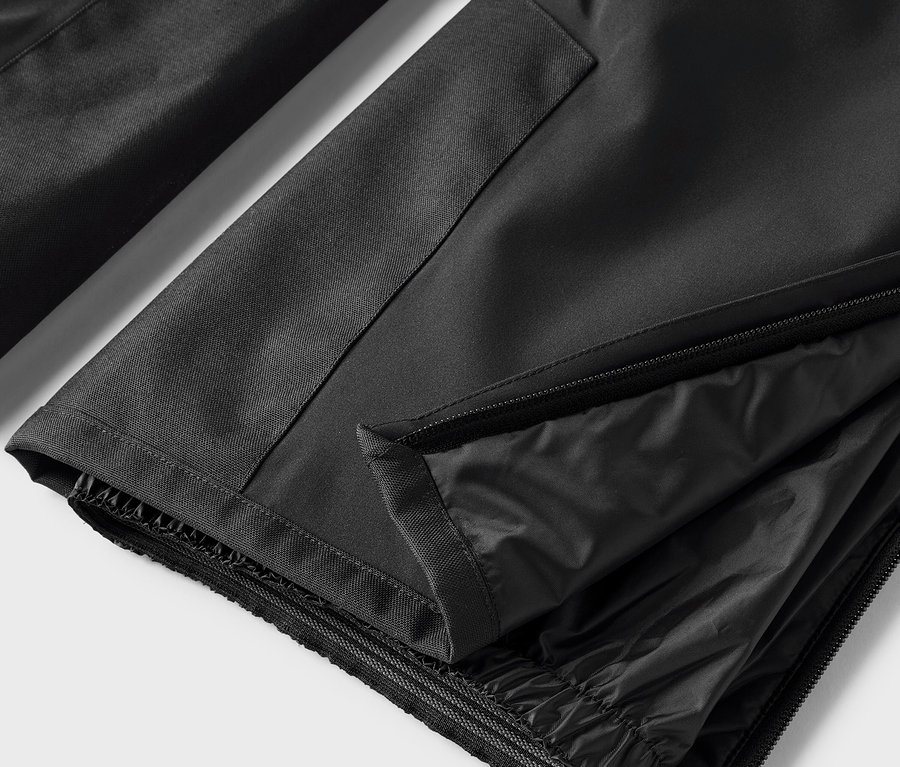 Detail černých kalhot s rozepnutým zipem.