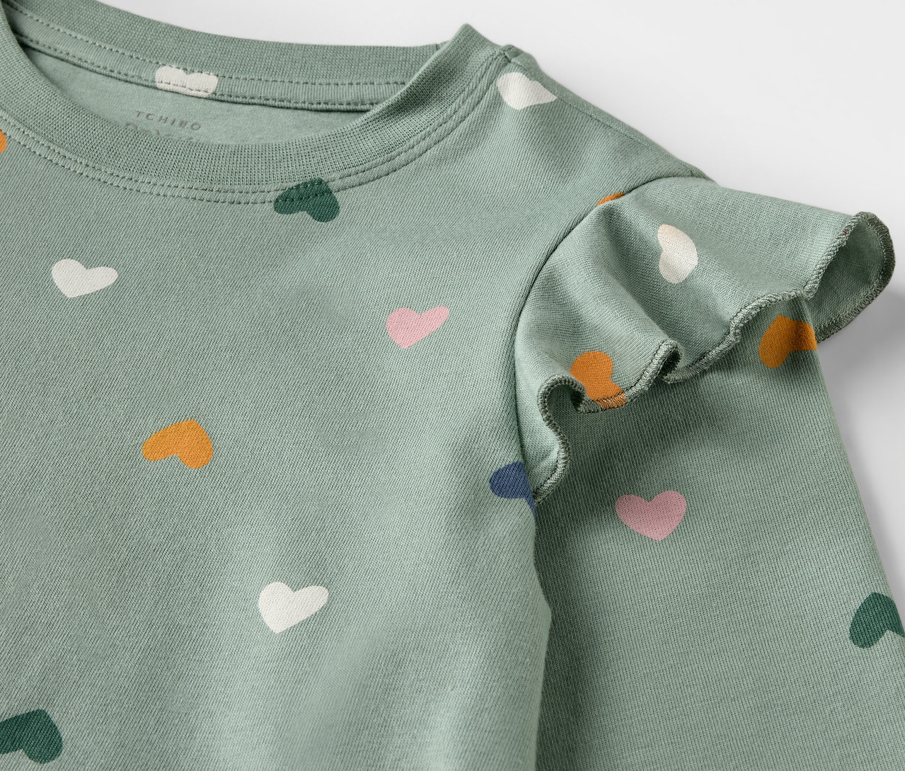 Detail dětské noční košile s potiskem srdíček.