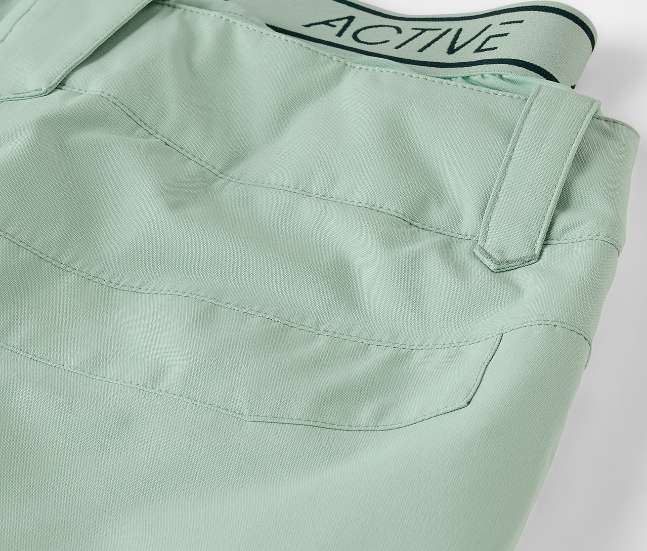 Detail světle zelených kalhot s kapsou a pasem s nápisem ACTIVE.