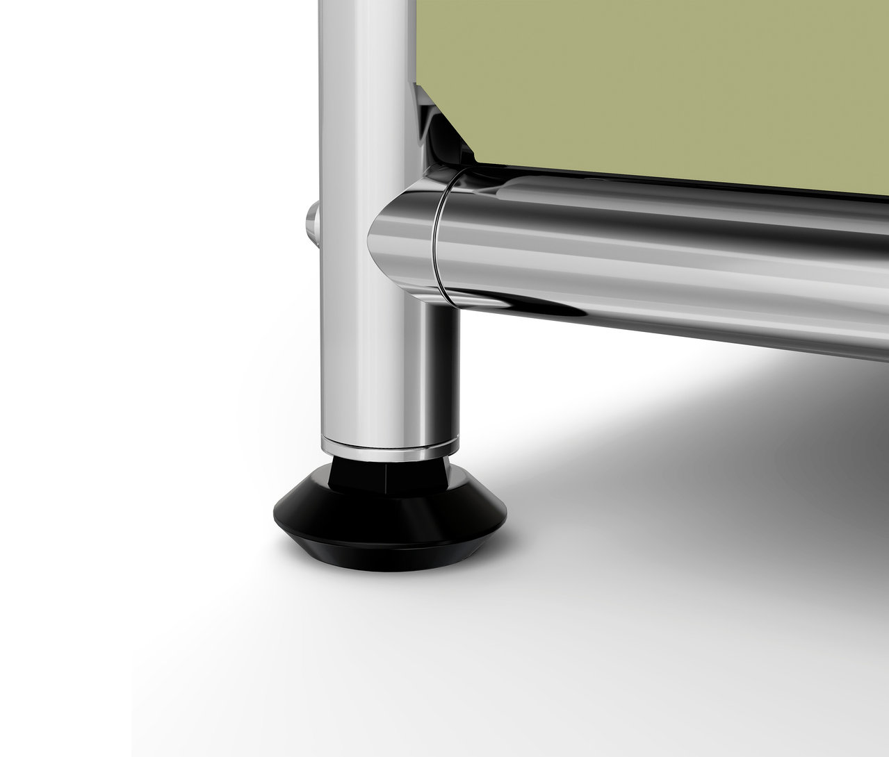 Detail chromované nohy s černou patkou a světlé desky nábytku.