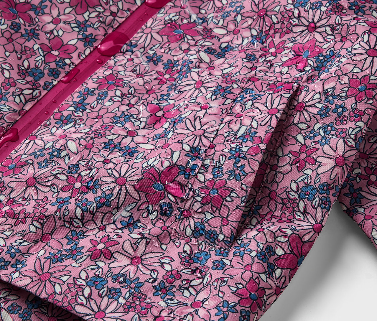 Detail dětské termo bundy do deště s květinovým vzorem.