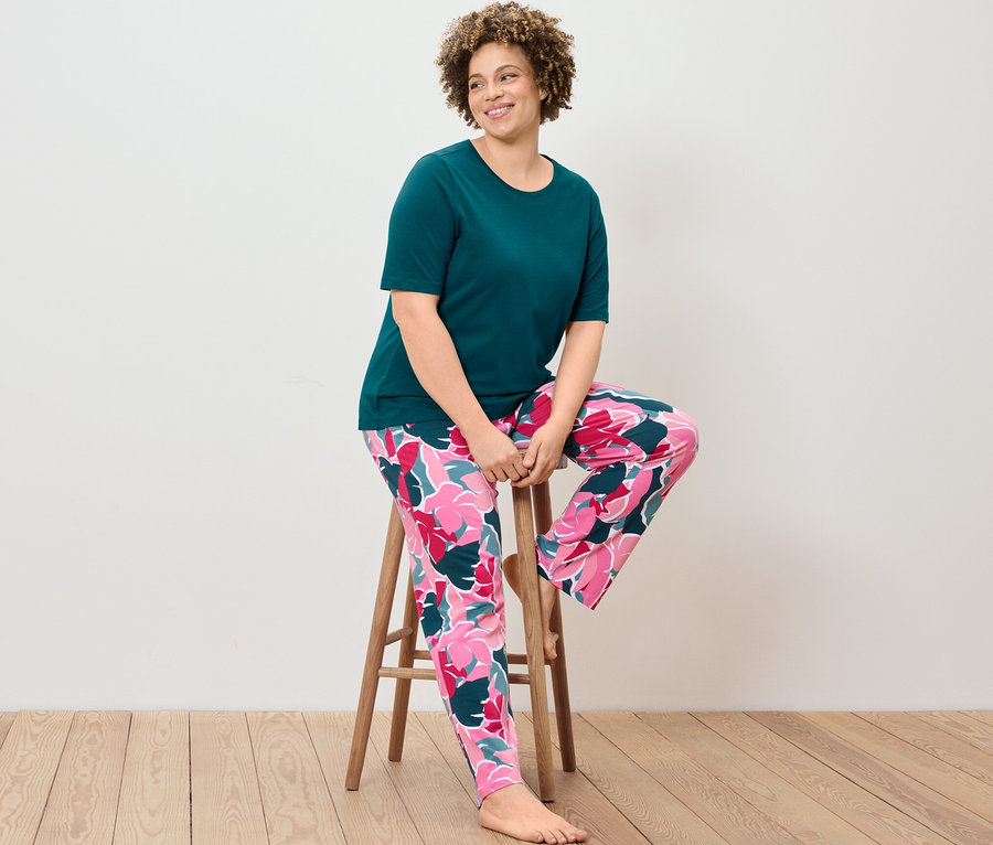 Žena sedí na stoličce v pyžamové soupravě.