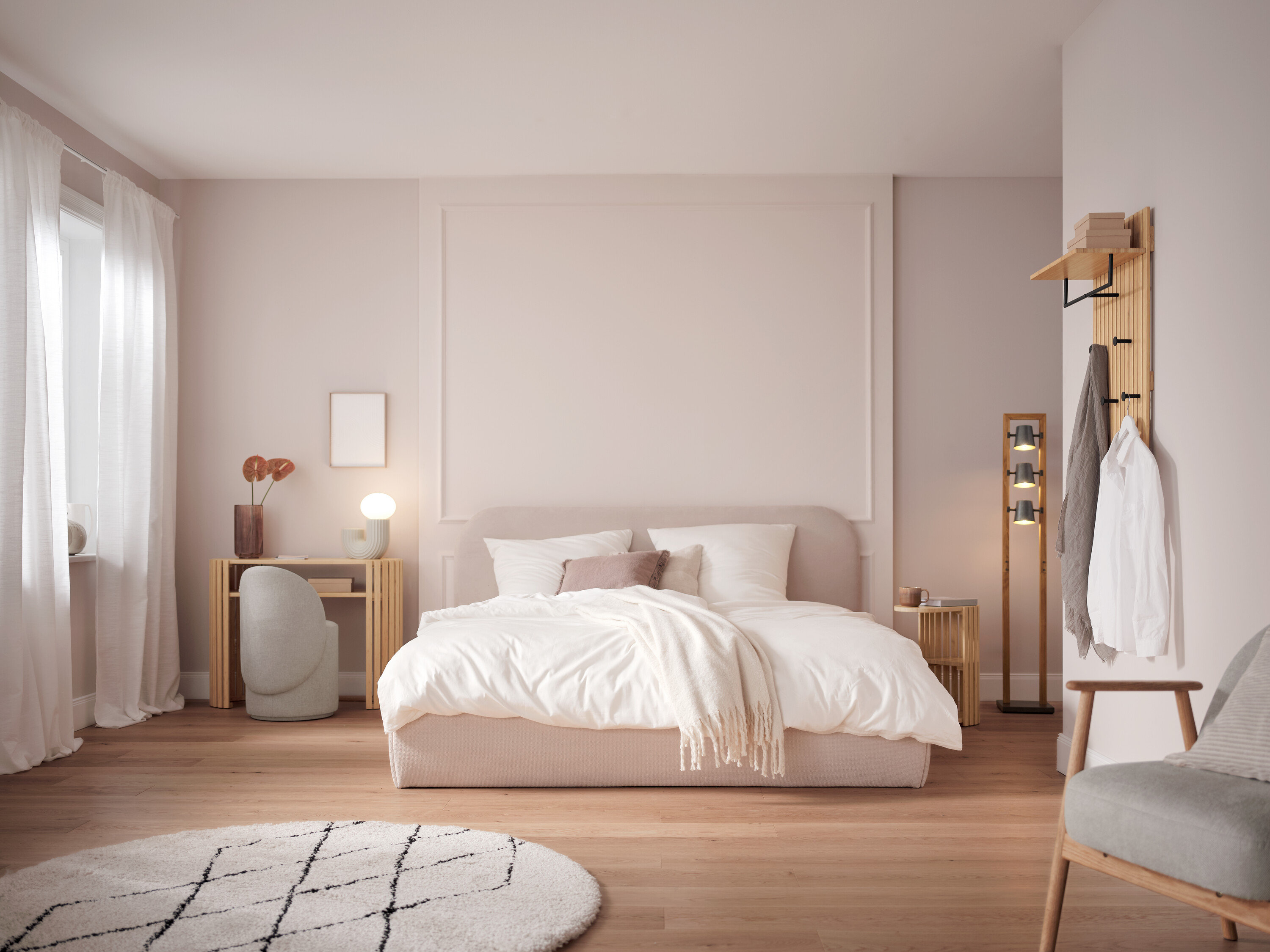 Ložnice s postelí s bílým povlečením, stolem, židlí a dekoracemi.