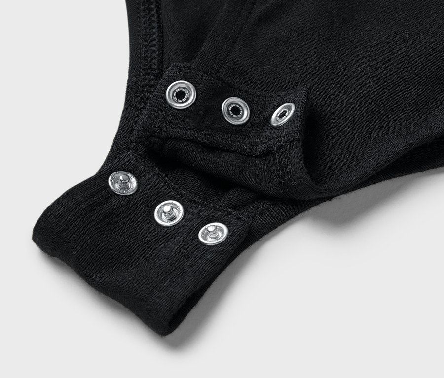 Detail černého body s patentkami v rozkroku.