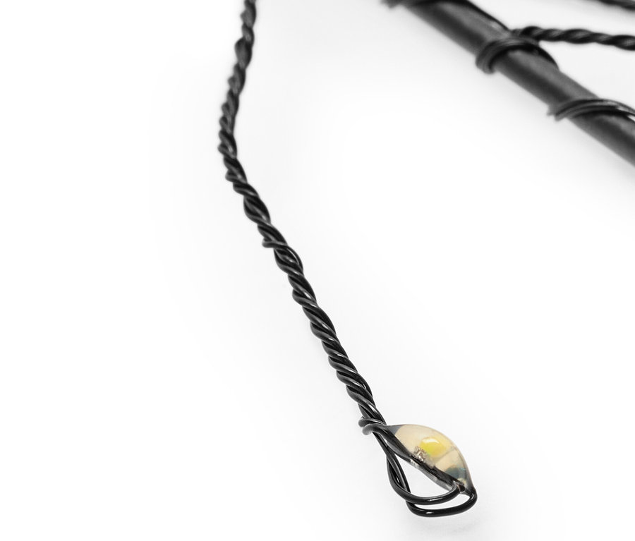 Detail solárního zápichu ze 3 ks s černým drátem a LED světlem.