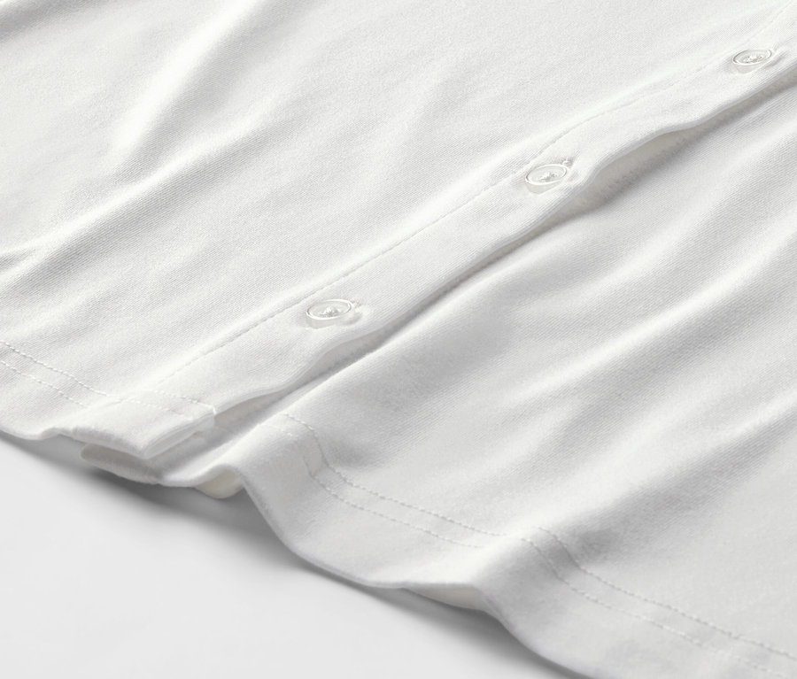 Detail bílého halenkového trička s knoflíkovou légou.