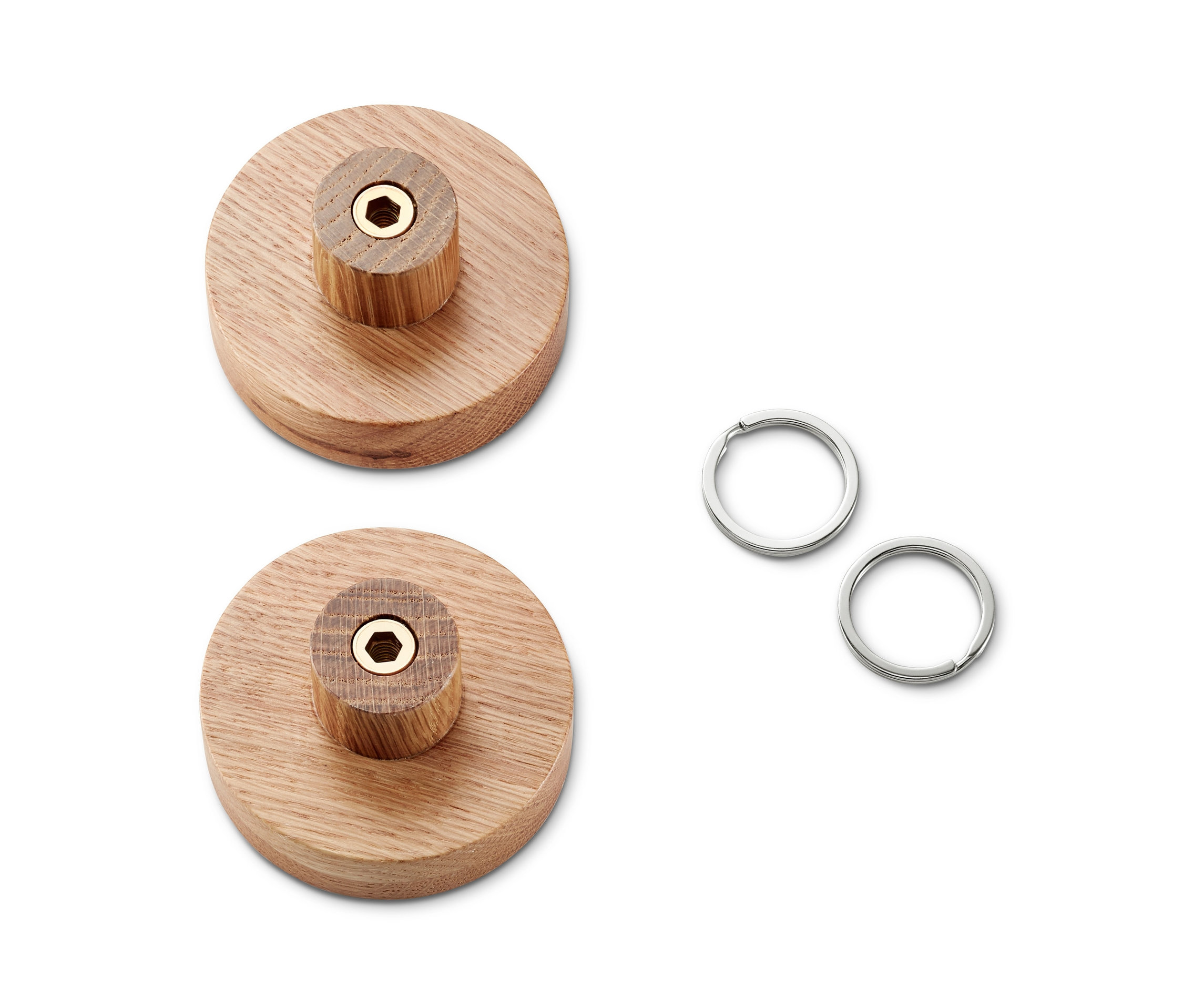 Dva nástěnné háčky z masivního dřeva a dva stříbrné kroužky na klíče na bílém pozadí.