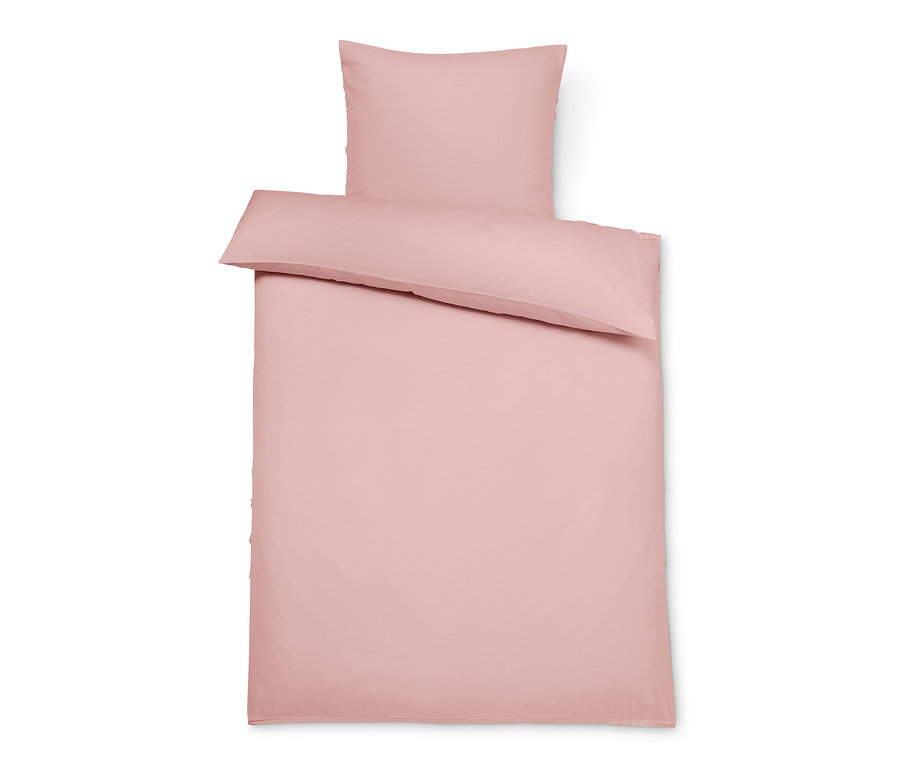 Růžové strukturované povlečení standardní velikosti složené na sobě.