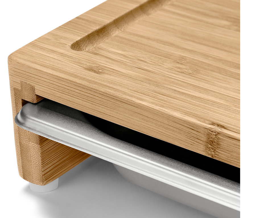 Detailní záběr na krájecí prkénko s kovovou zásuvkou.