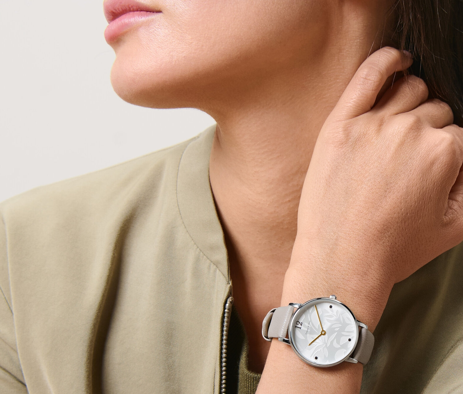 Žena nosí dámské náramkové hodinky.