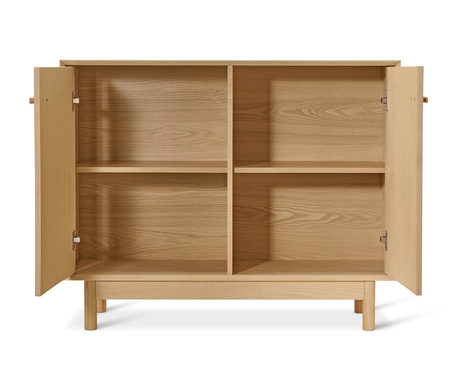 Komoda z jasanového dřeva s otevřenými dvířky.