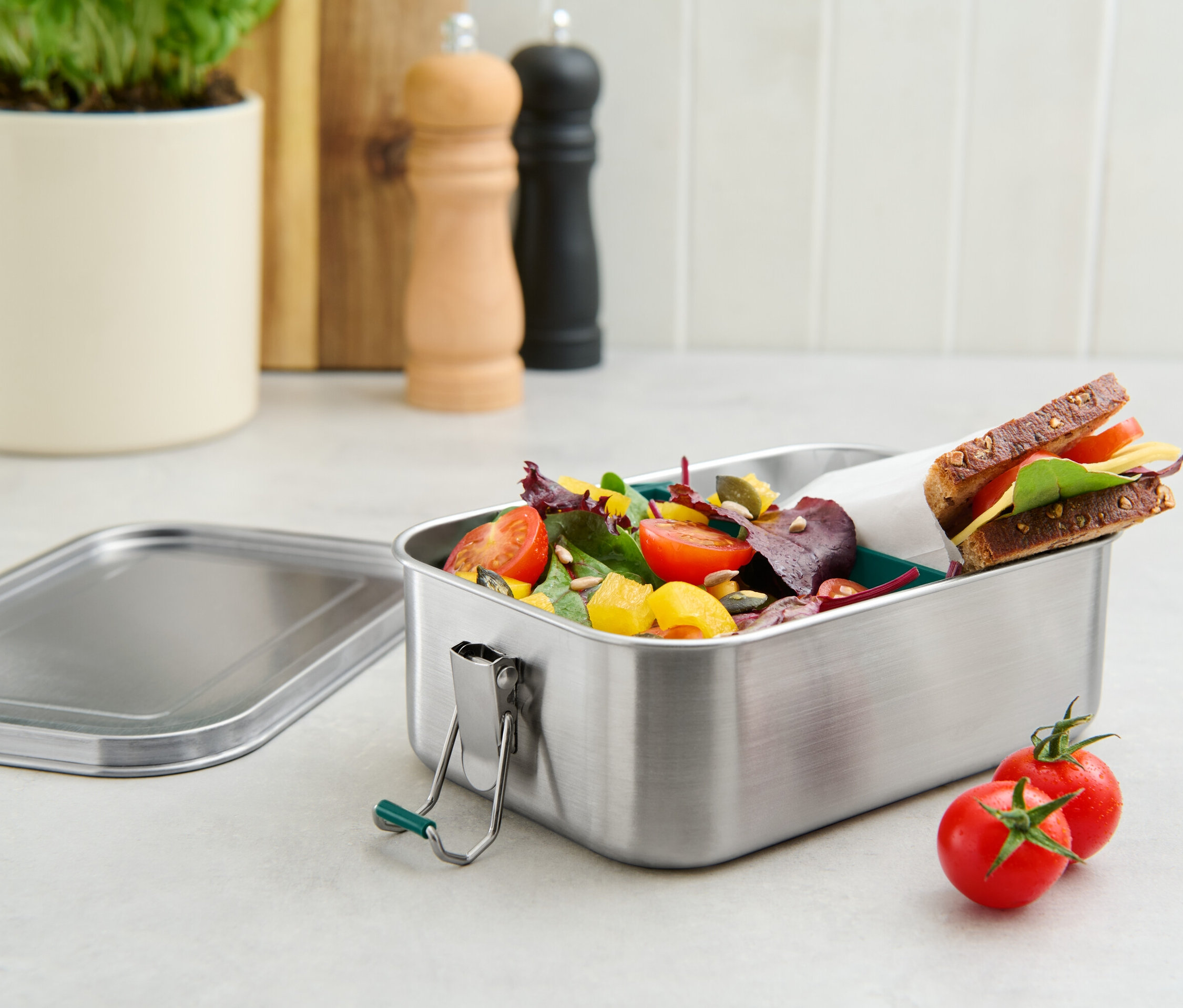 Nerezový svačinový box na cesty s obsahem salátu a sendviče.