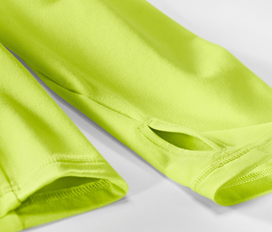 Detail neonově limetkového funkčního termotrika s otvory pro palce.