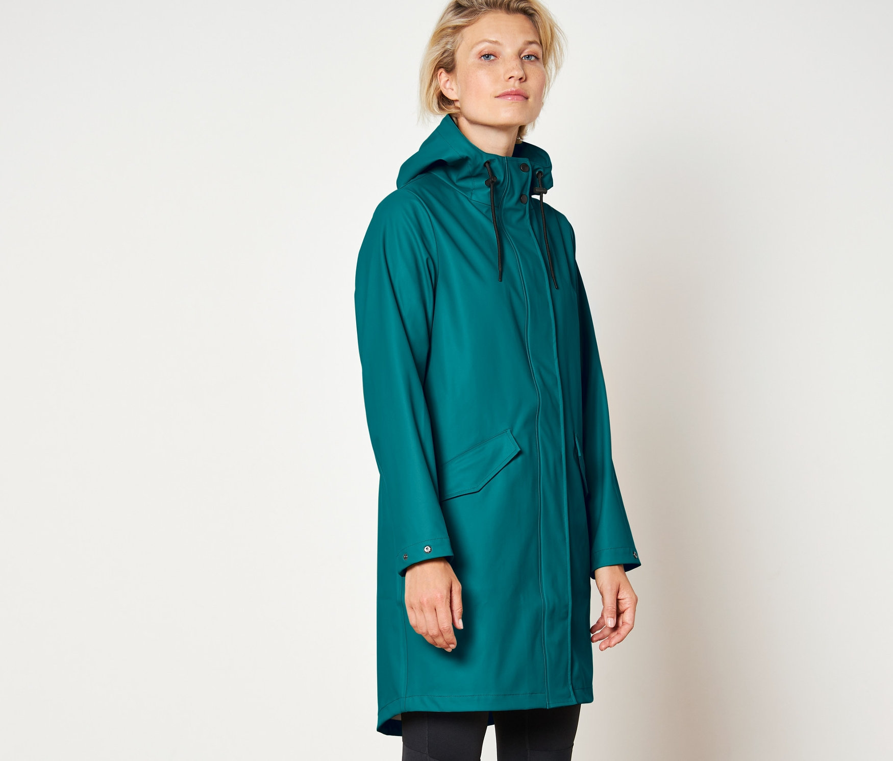 Žena má na sobě kabát do deště.