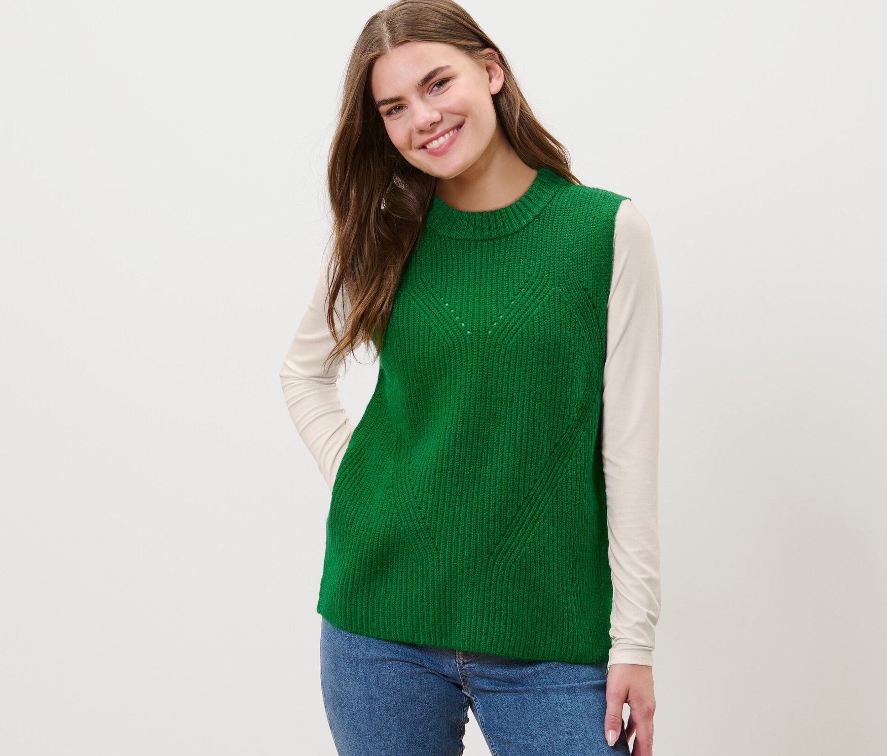 Žena má na sobě zelenou pletenou vestu.