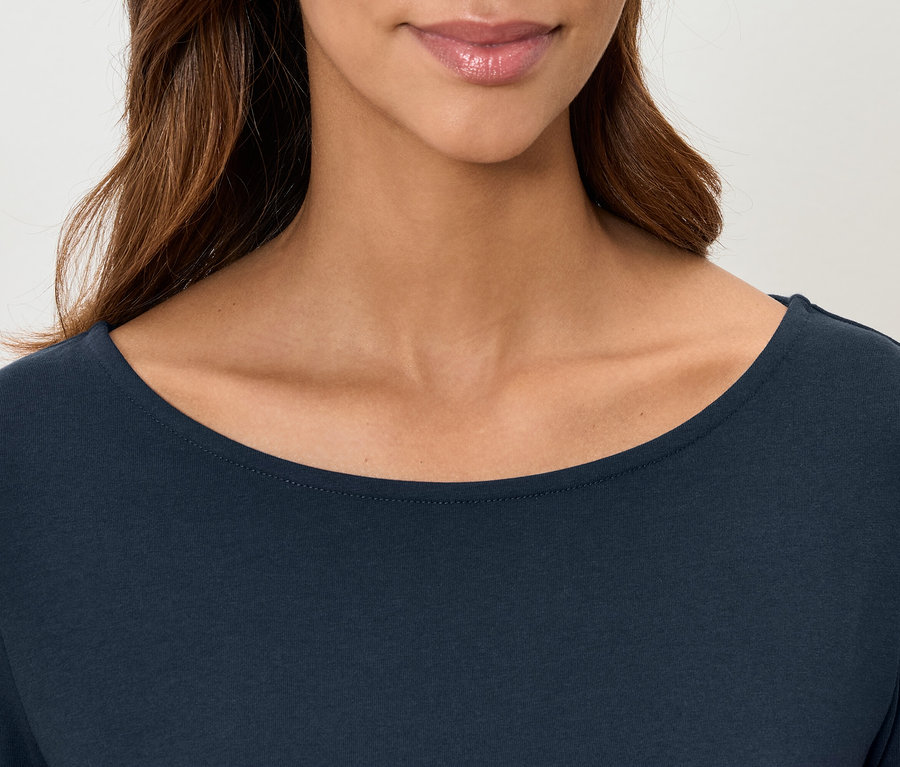 Detail dámského topu s dlouhým rukávem v tmavě modré barvě, zobrazený od ramen po horní ret.