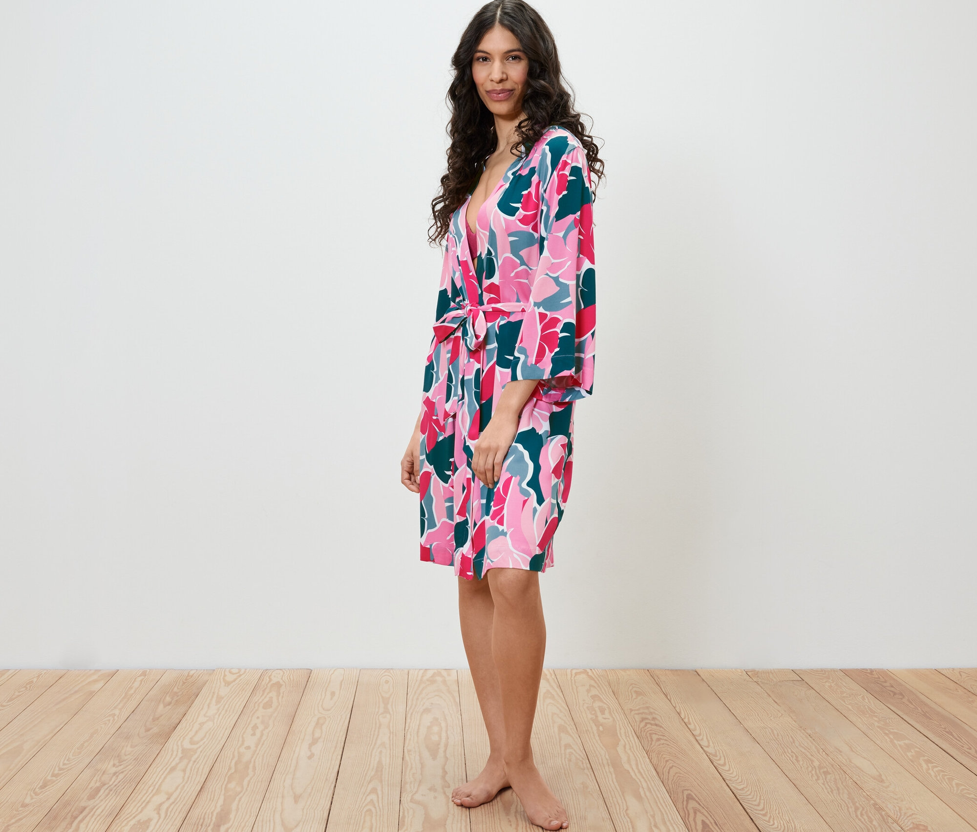 Žena stojící bokem a má na sobě župan s květinovým vzorem.