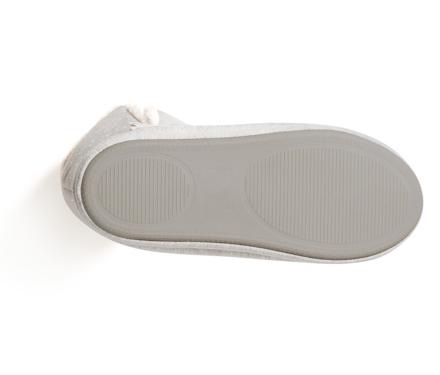 Detailní pohled na podrážku vysokých domácích pantoflí na bílém pozadí.