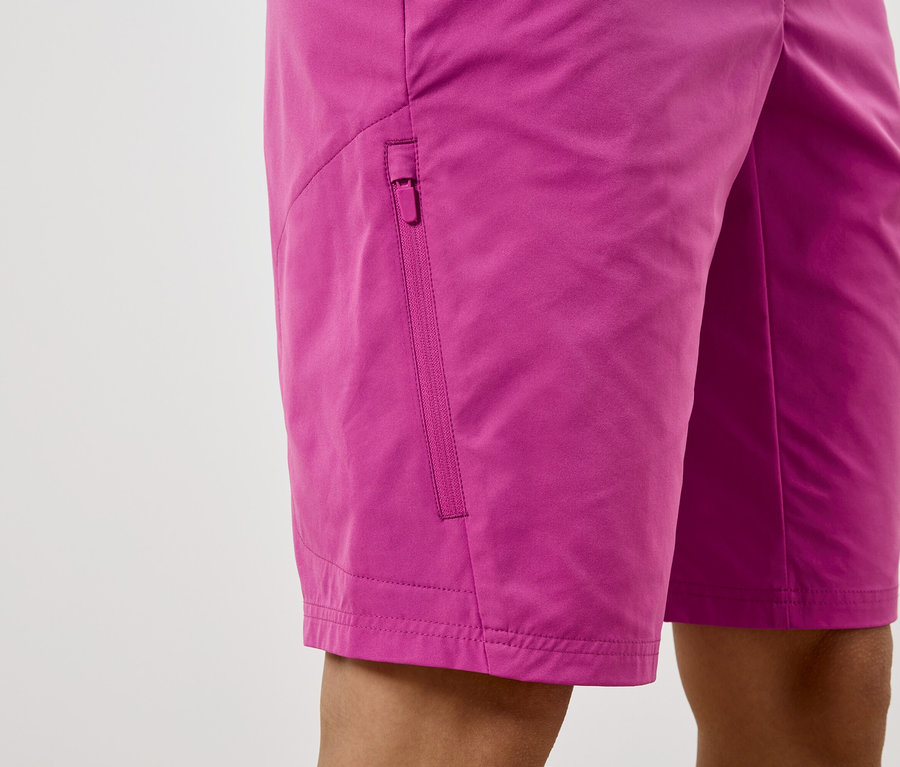 Detailní záběr na růžové šortky s kapsou na zip.