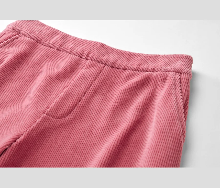 Detail růžových manšestrových kalhot s elastickým pasem a boční kapsou.