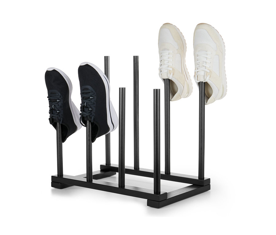 Dva páry bot umístěné na černém stojanu na boty.
