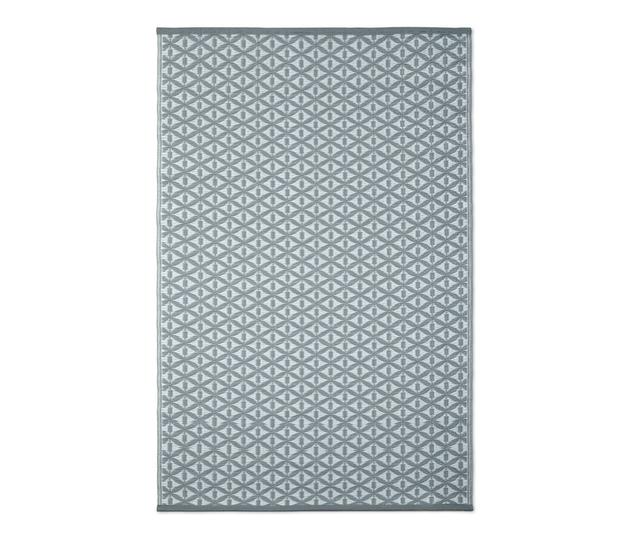Šedý venkovní koberec s geometrickým vzorem.