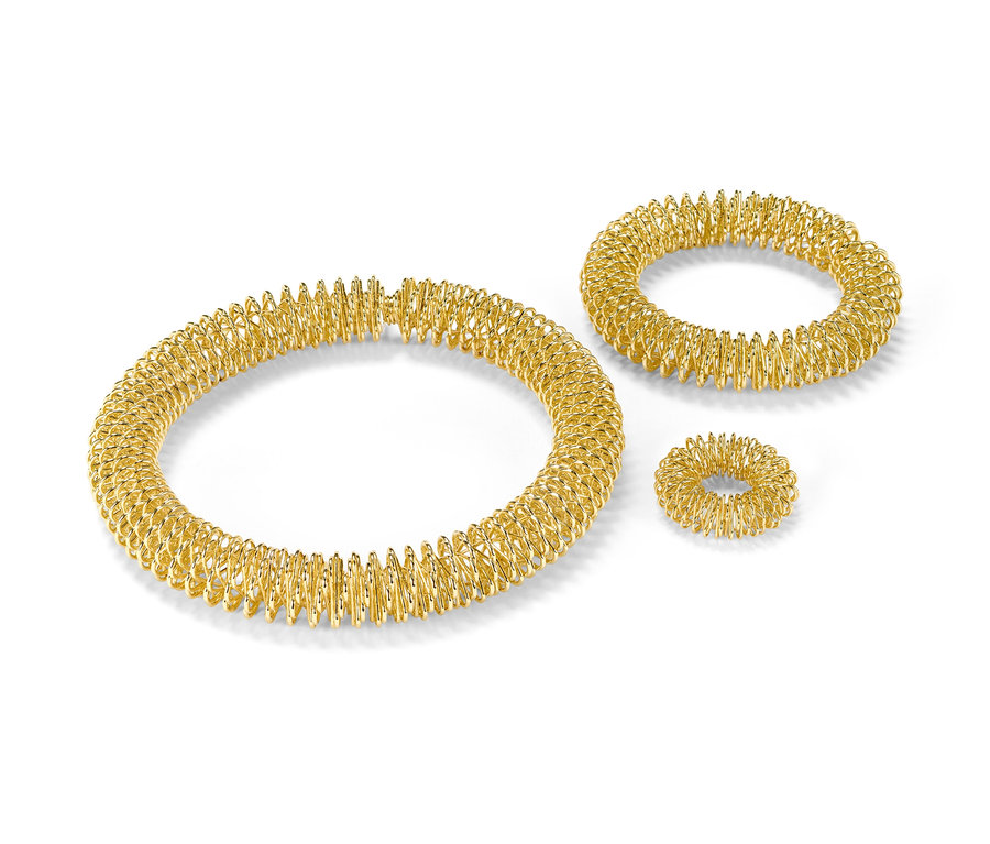 Zlatá akupresurní sada na bílém pozadí.