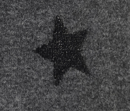 Detail pletených šatů s rolákem s motivem hvězdy.