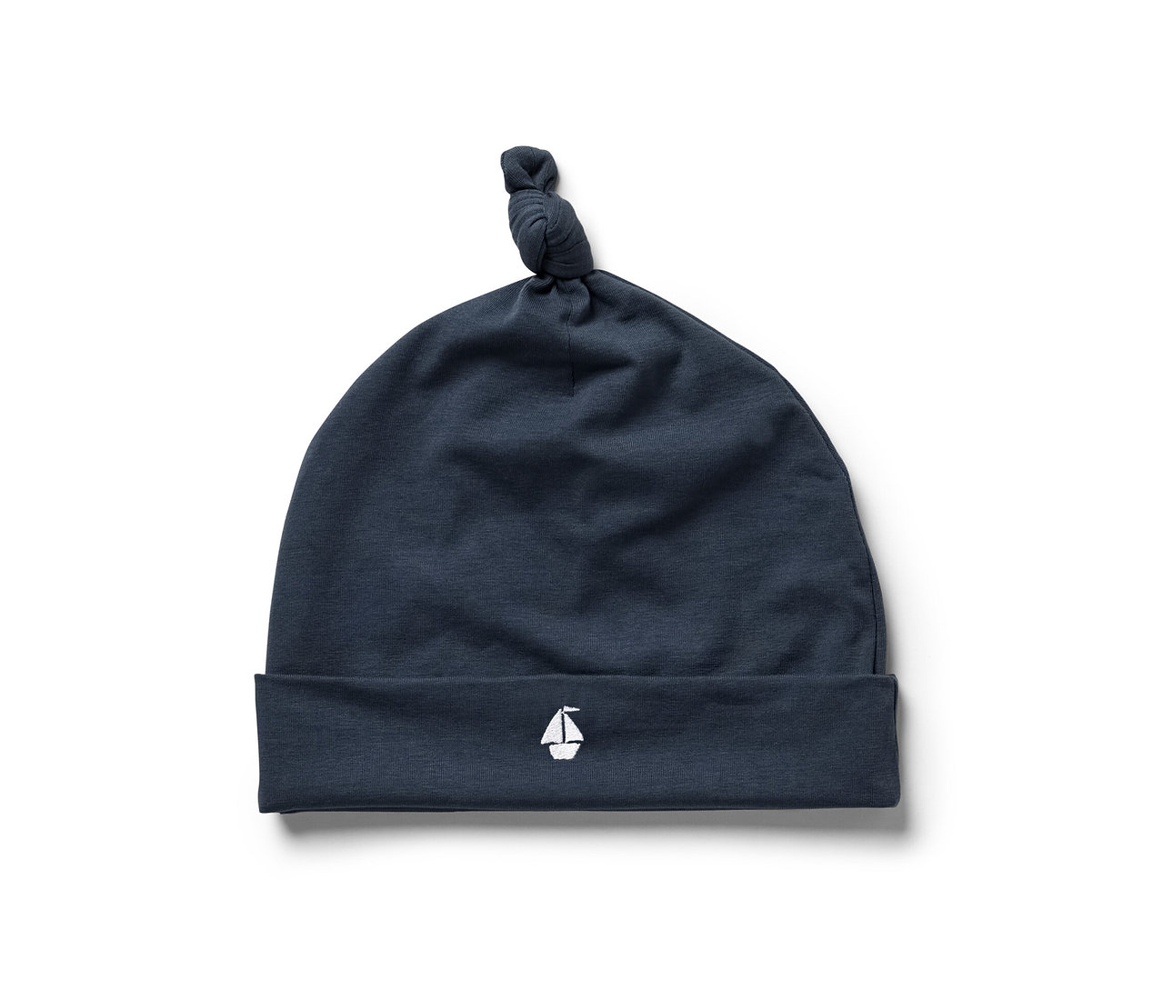 Tmavě modrá čepice ze soupravy pro miminka s malou bílou výšivkou plachetnice.