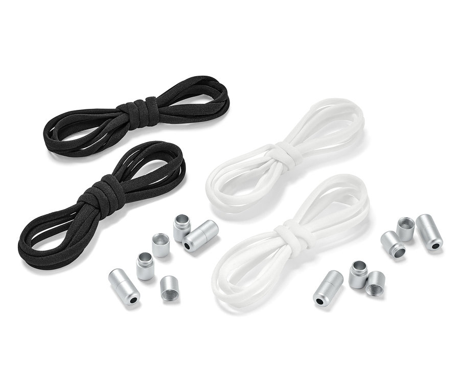 Dva páry elastických tkaniček, jedny černé a druhé bílé, leží vedle sebe s kovovými koncovkami.