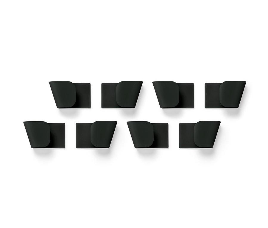 Osm černých nástěnných držáků na pokličky, 4 ks, uspořádaných ve dvou řadách na bílém pozadí.