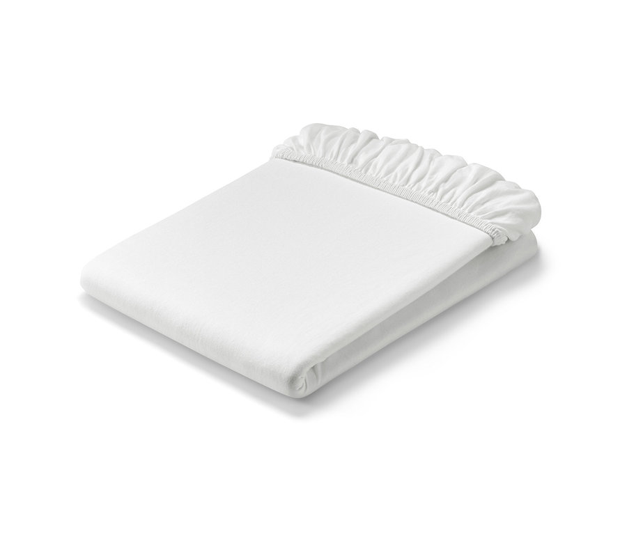 Složené bílé žerzejové prostěradlo s napínací gumou.