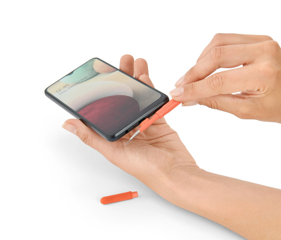 Žena čistí telefon sadou na čištění psacího stolu 4 v 1.