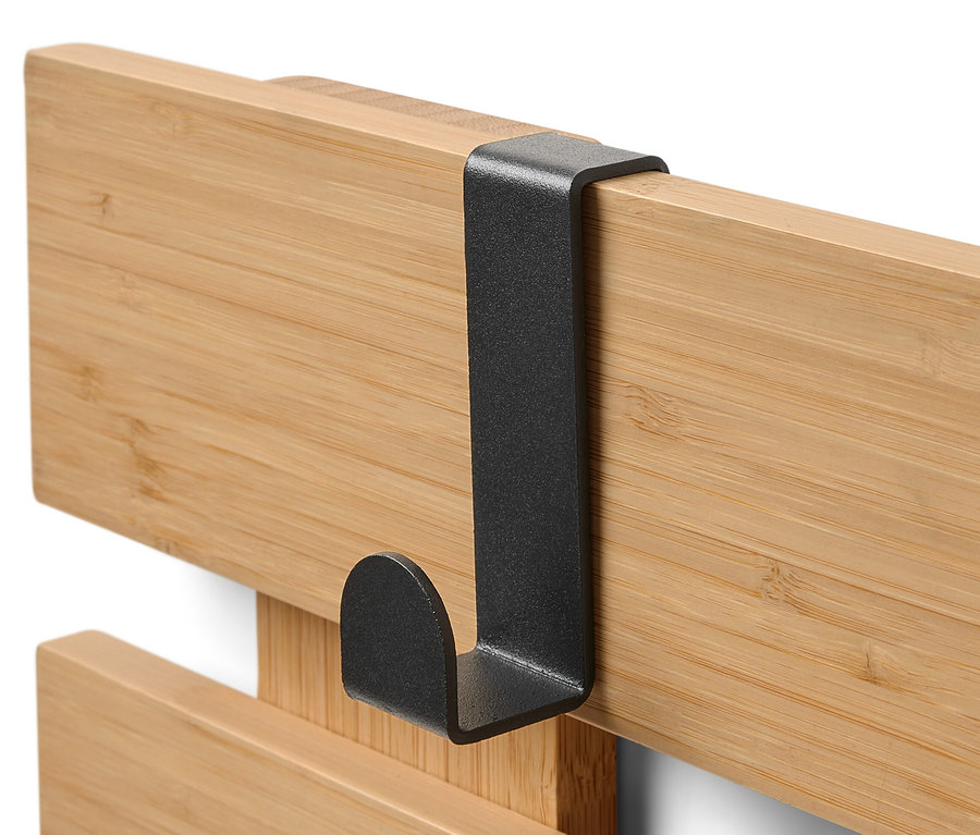 Detail nástěnného regálu s ohebnými háčky a policí.